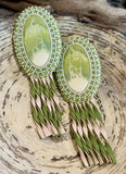 Swirling green oval beaded earrings with leather fringe