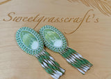 Swirling green oval beaded earrings with leather fringe